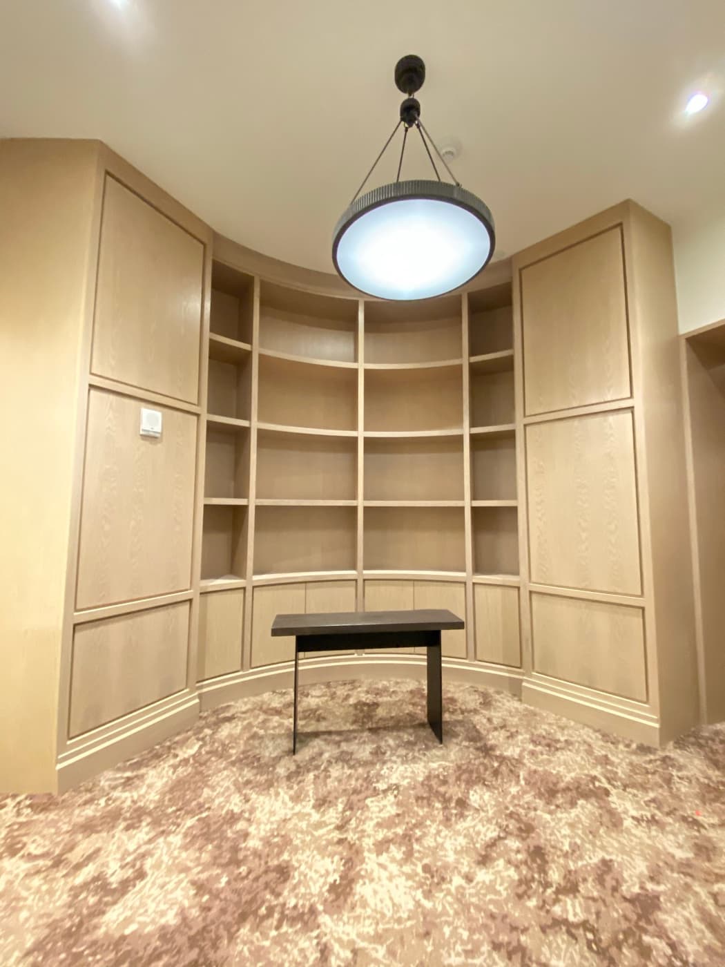 Study alcove featuring curved pale timber built-in shelving and custom wall panelling