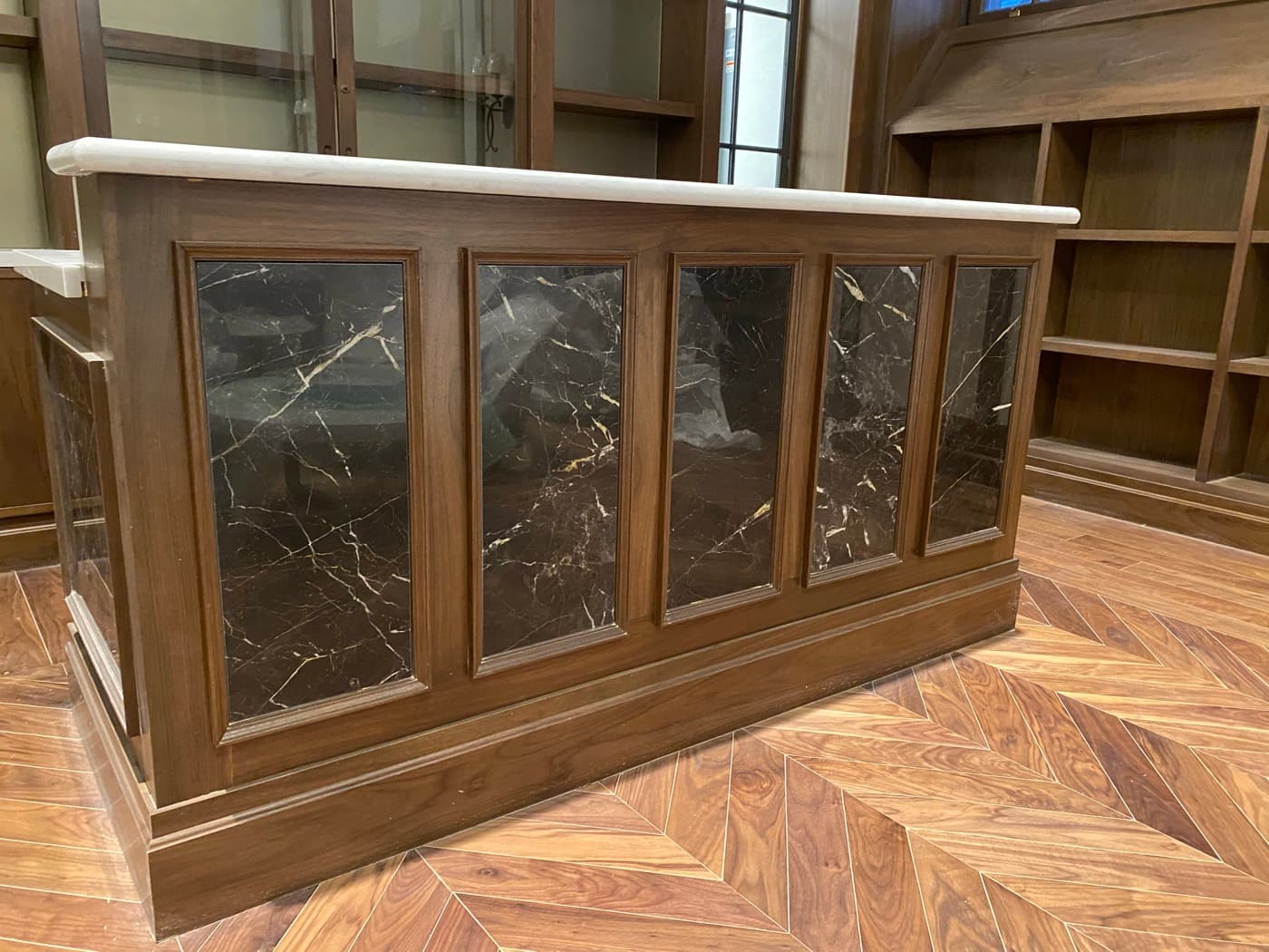 Home bar with custom dark timber counter featuring inset veined stone panels