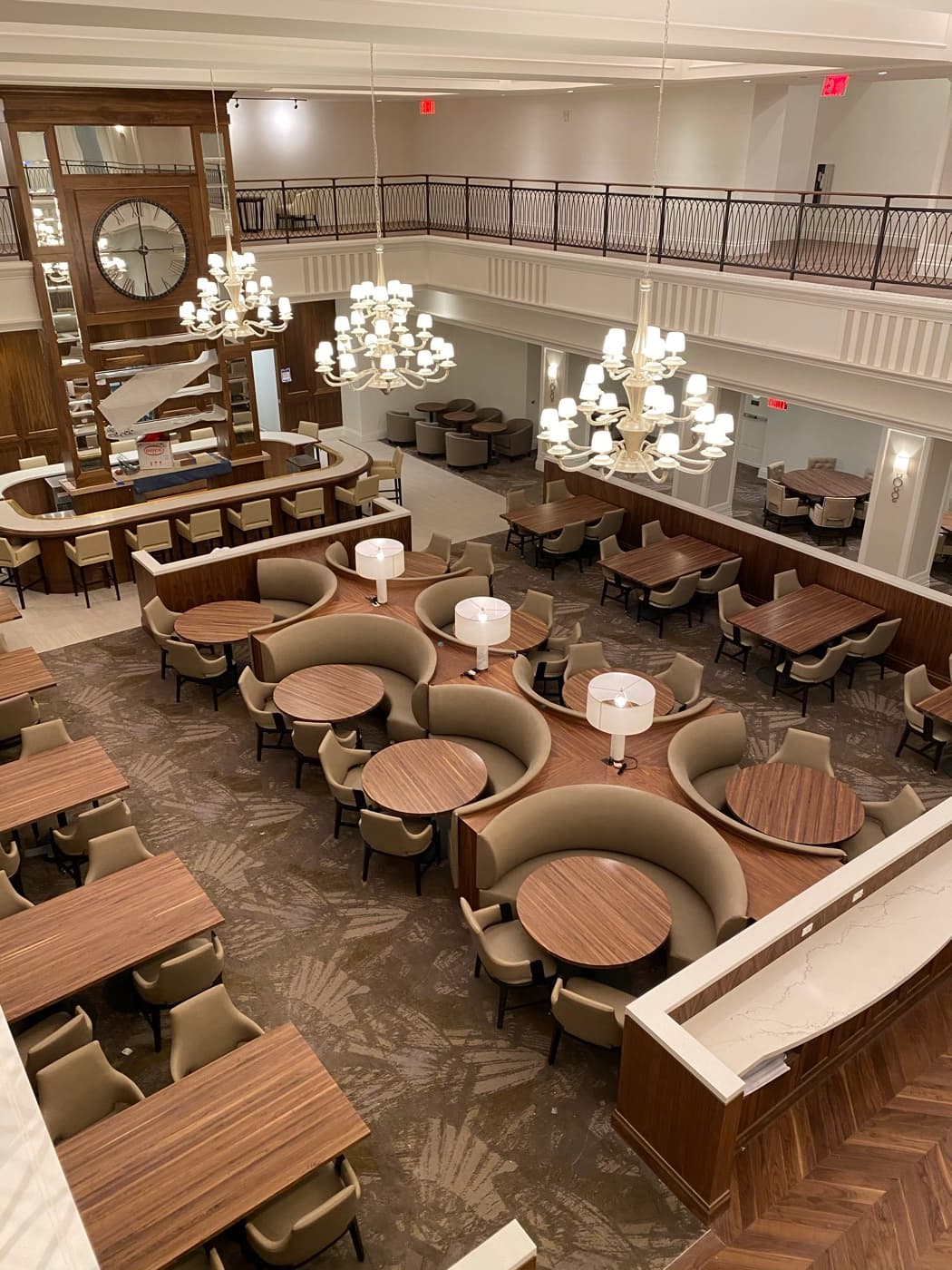 Dining hall with custom curved timber banquettes, dining tables, and built-in bar counter