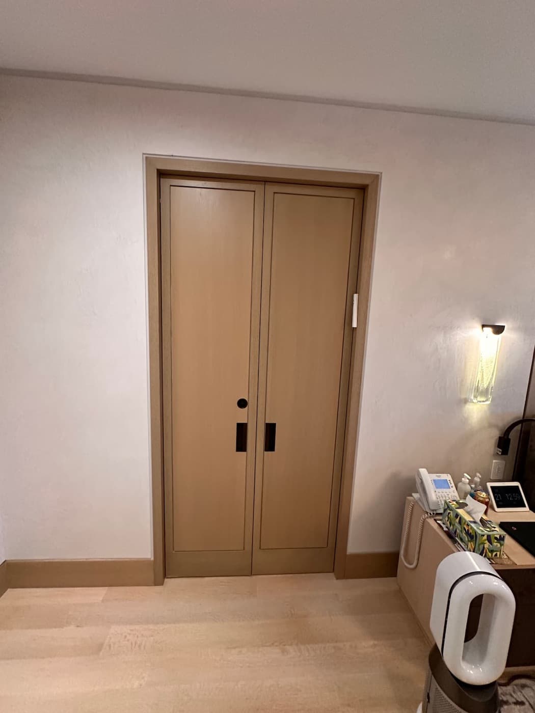 Bedroom featuring custom light timber double doors with dark recessed hardware and matching baseboards