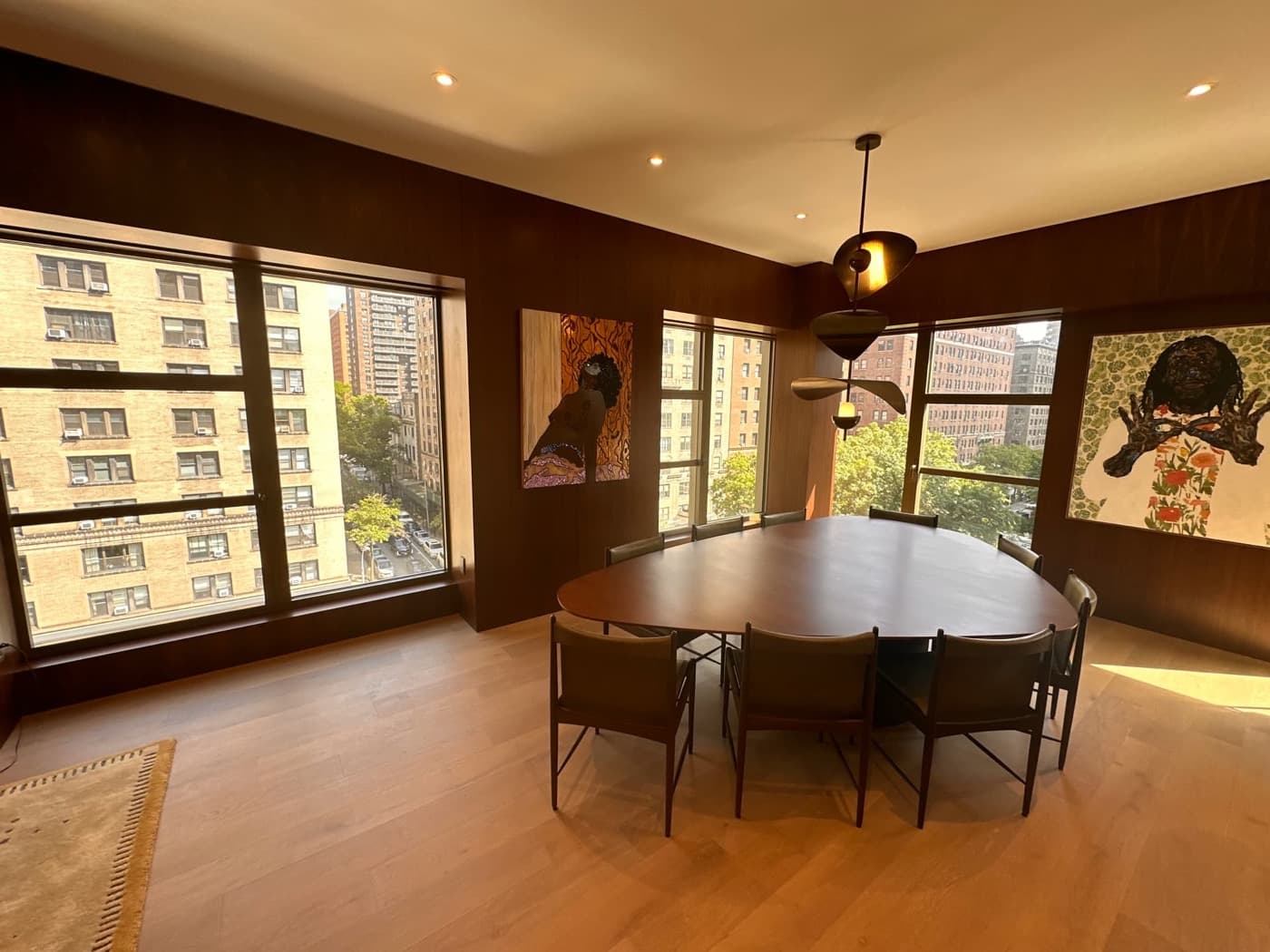 Dining room with dark timber wall panelling, large windows, and a custom dining table