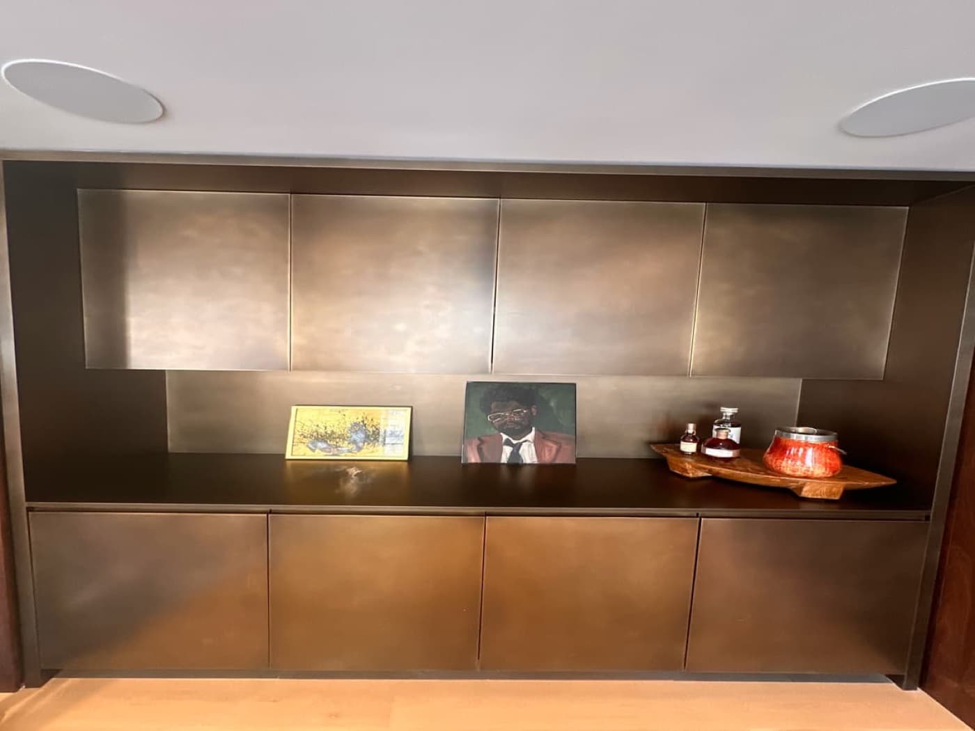 Contemporary living space with custom bronze-toned metal built-in cabinetry and display counter