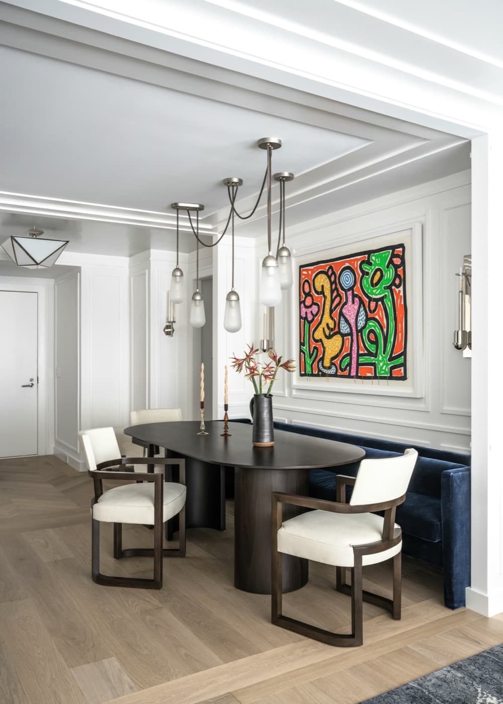 Dining area featuring moulded wall panelling, stepped ceiling details, and a dark timber table