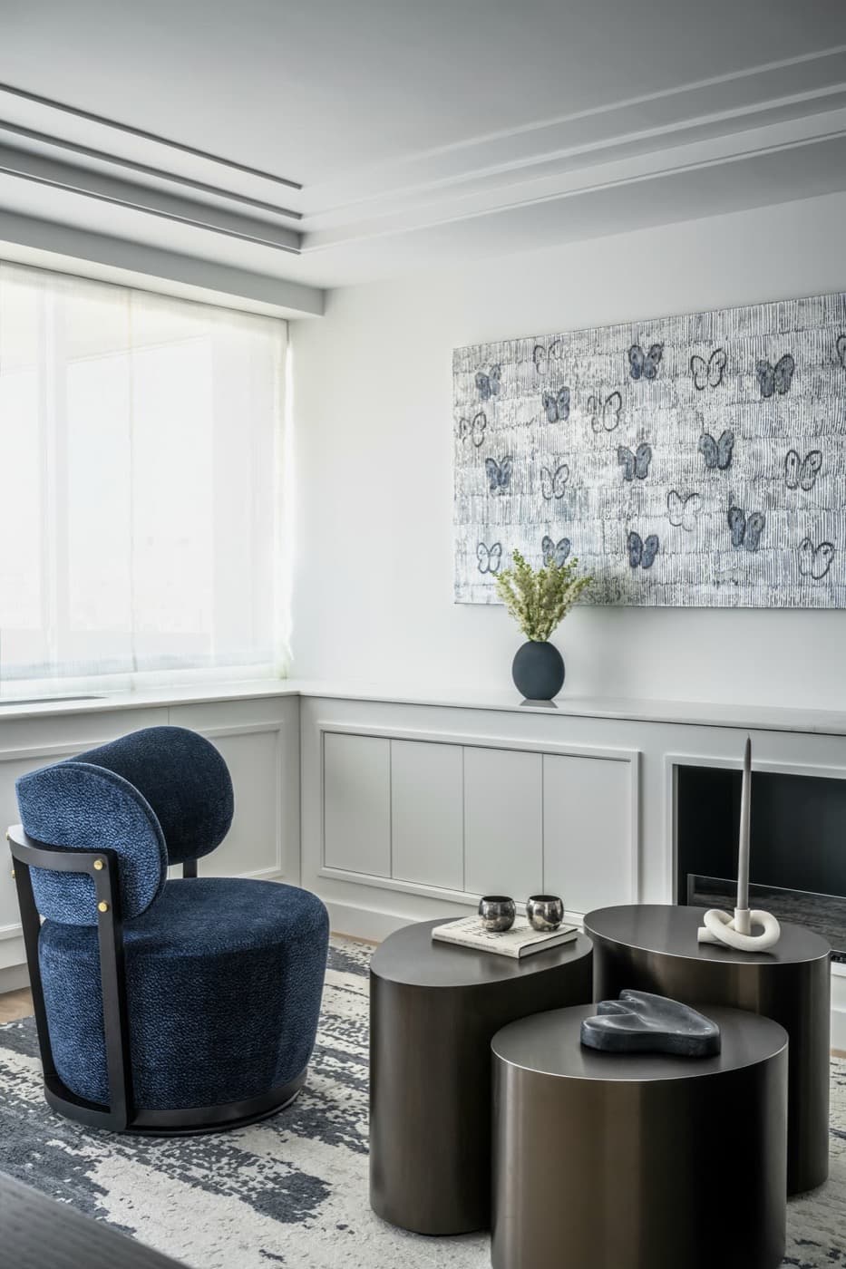 Living room with custom low panelled built-in cabinetry, modern fireplace, and stepped ceiling moulding