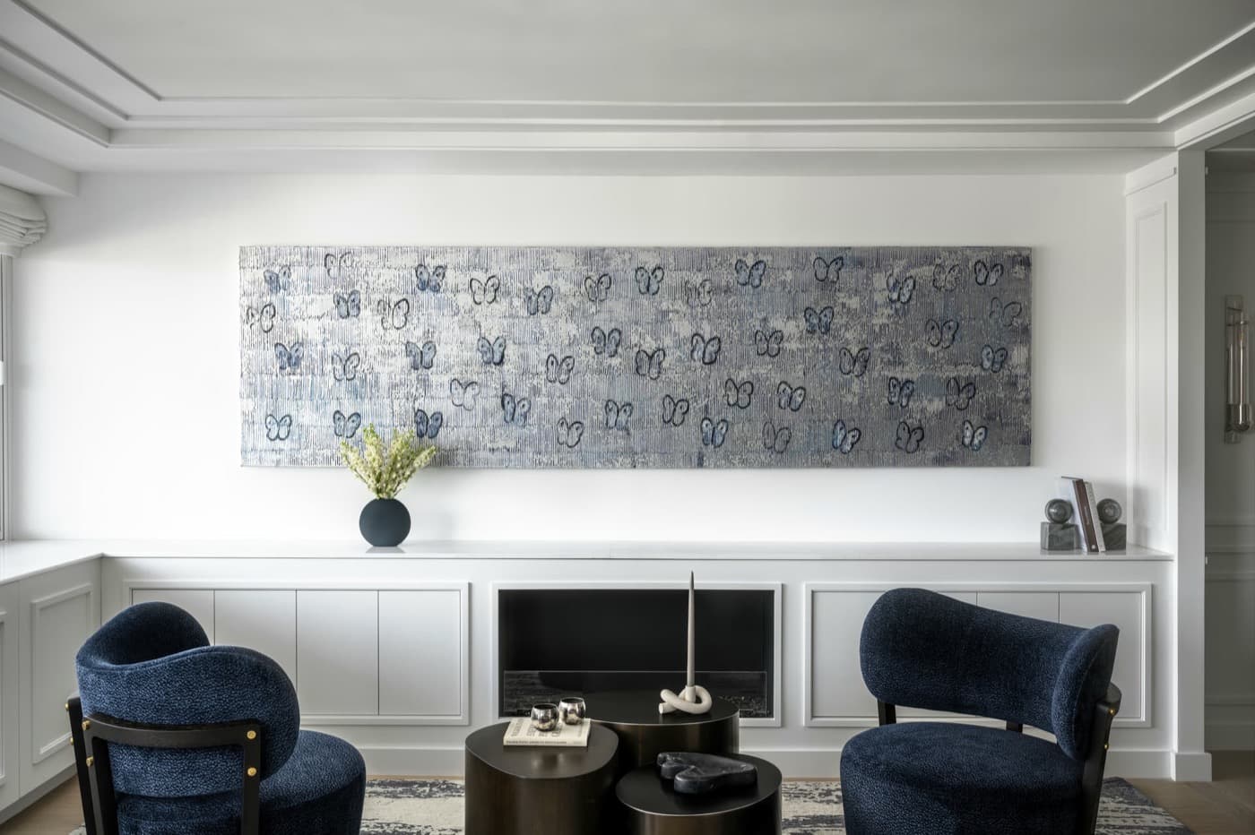 Living room with custom white low-profile cabinetry framing a modern built-in fireplace