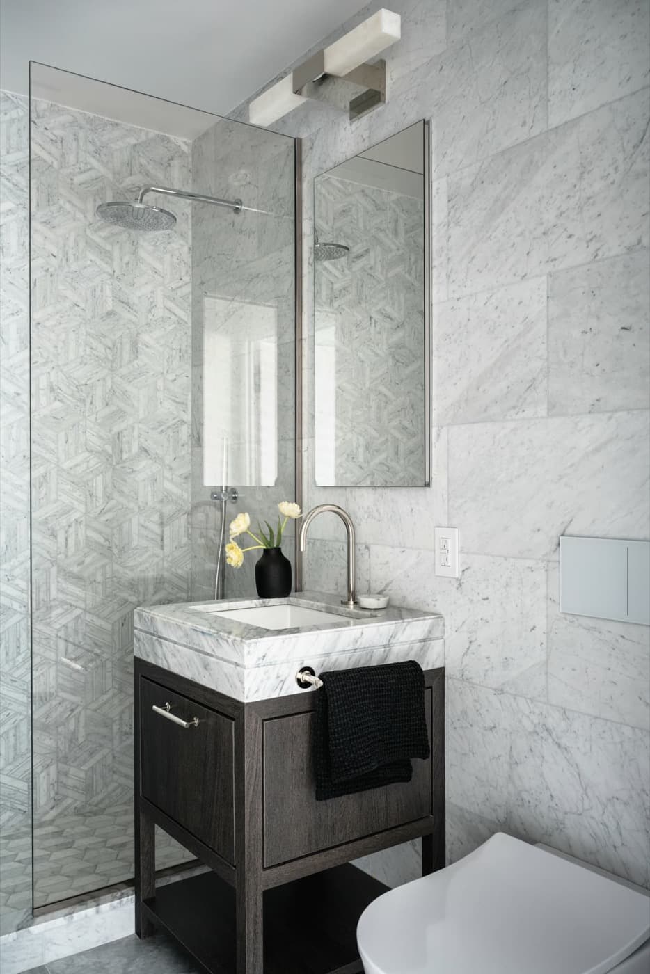 Bathroom with a dark timber vanity, pale veined stone countertop, and glass-enclosed shower