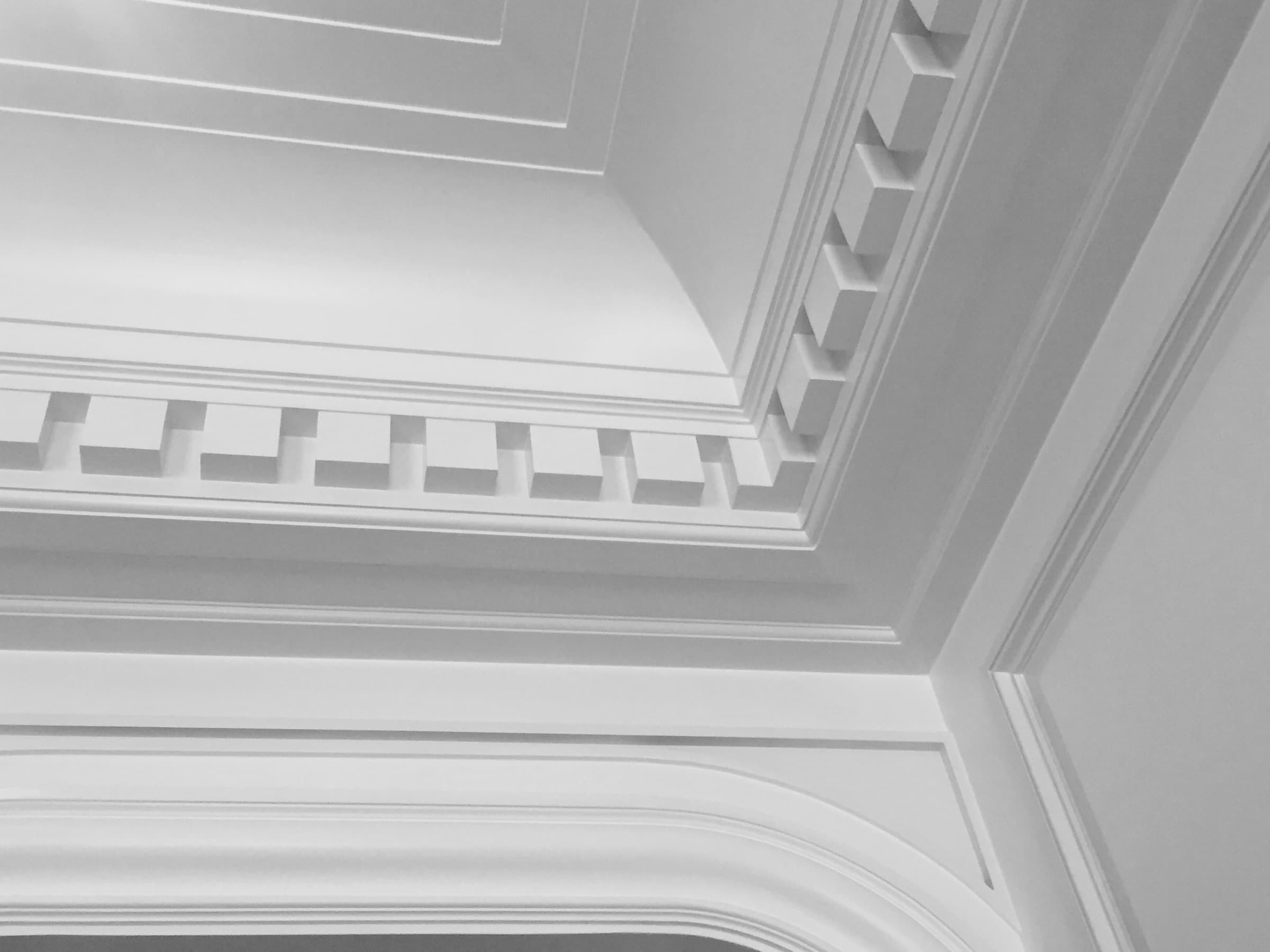 Interior ceiling detail with intricate stepped crown moulding and custom dentil trim