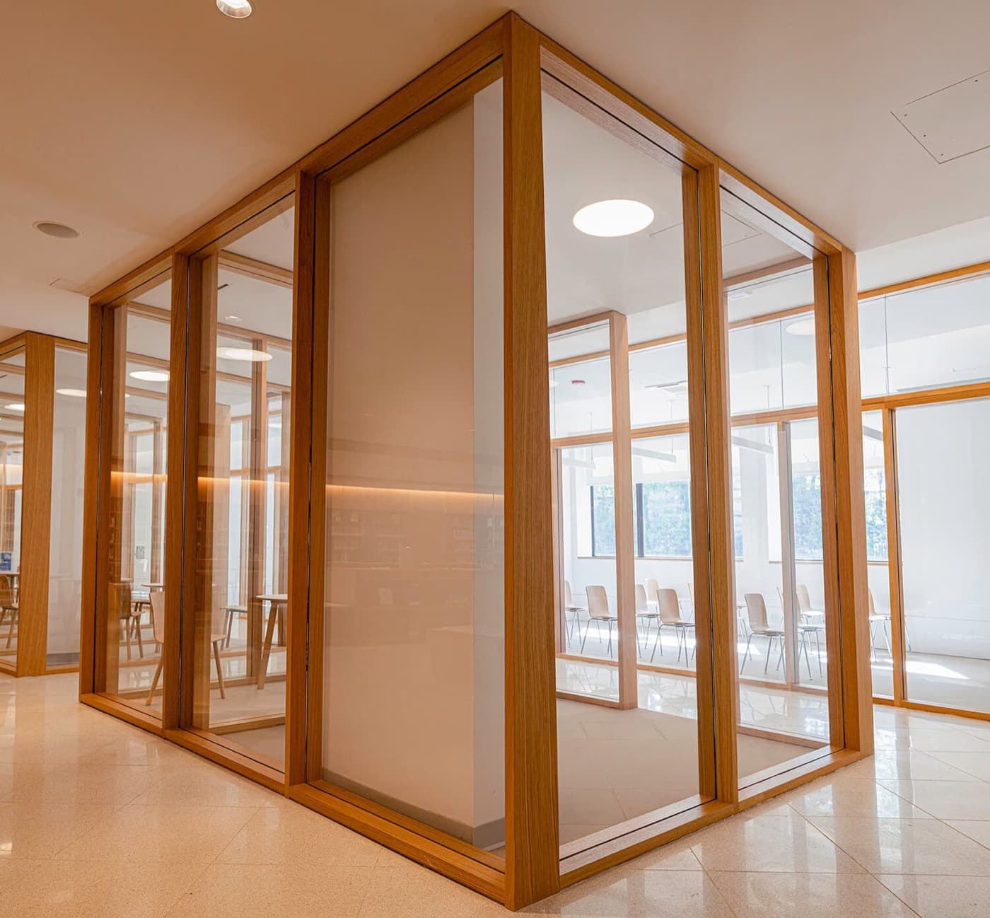 Commercial interior featuring custom timber-framed glass partition enclosures and polished stone flooring