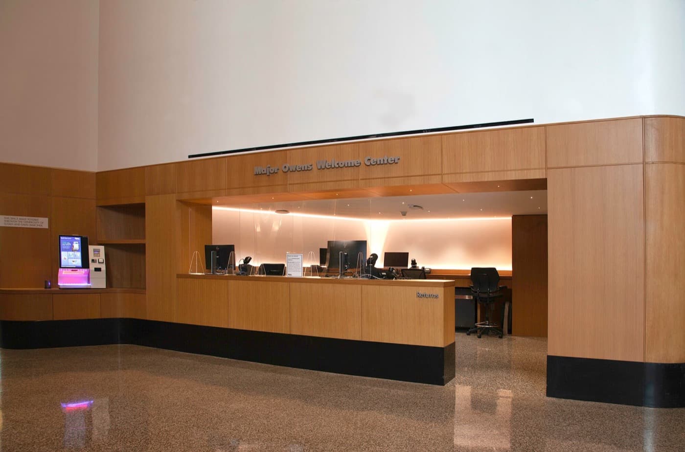 Welcome center lobby featuring warm timber wall panelling and a built-in reception counter
