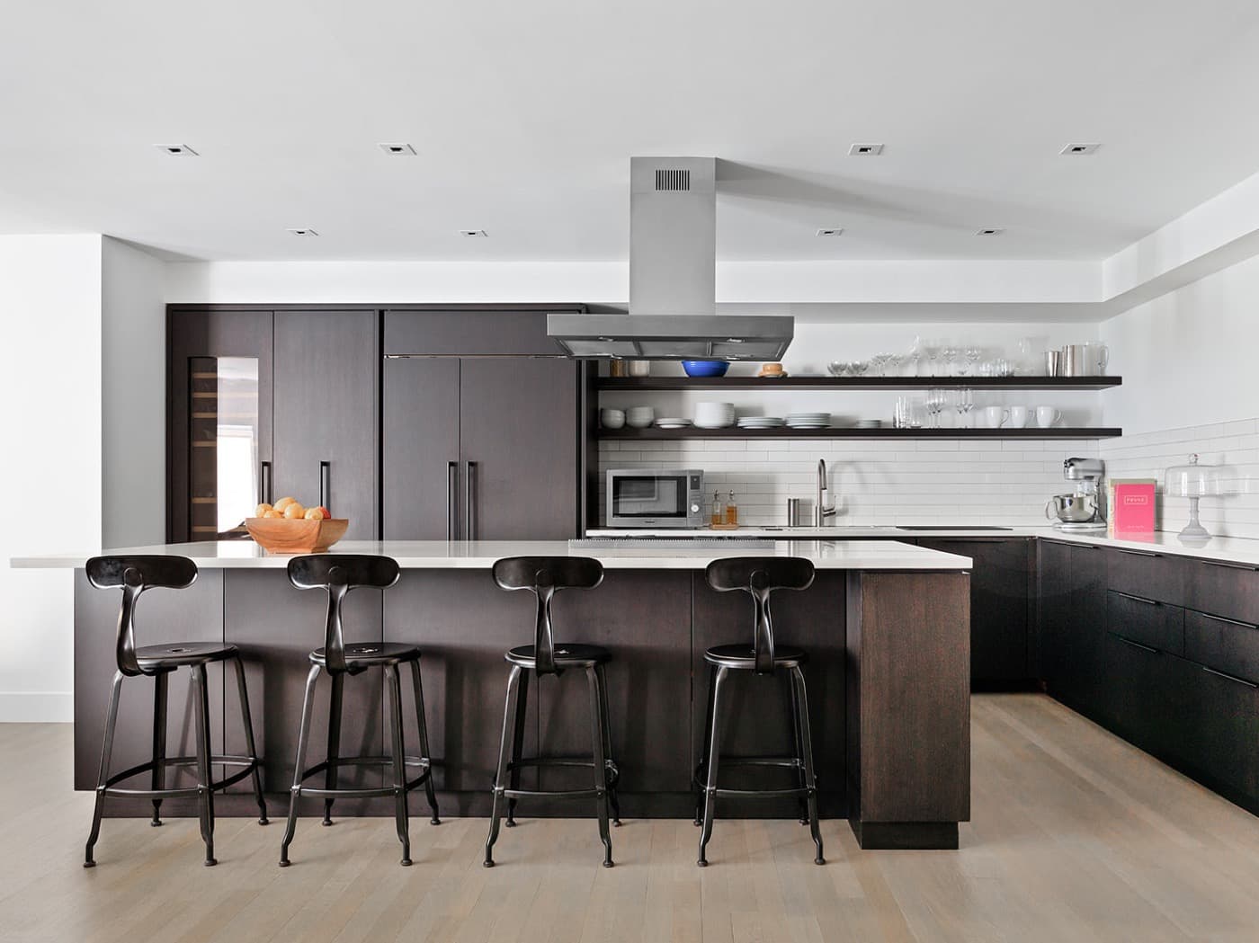 Kitchen with dark timber cabinetry, an island with white countertop and open floating shelves