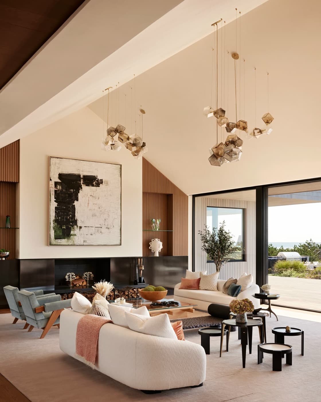 Living room with vaulted ceiling, slatted timber wall panelling, and dark fireplace surround