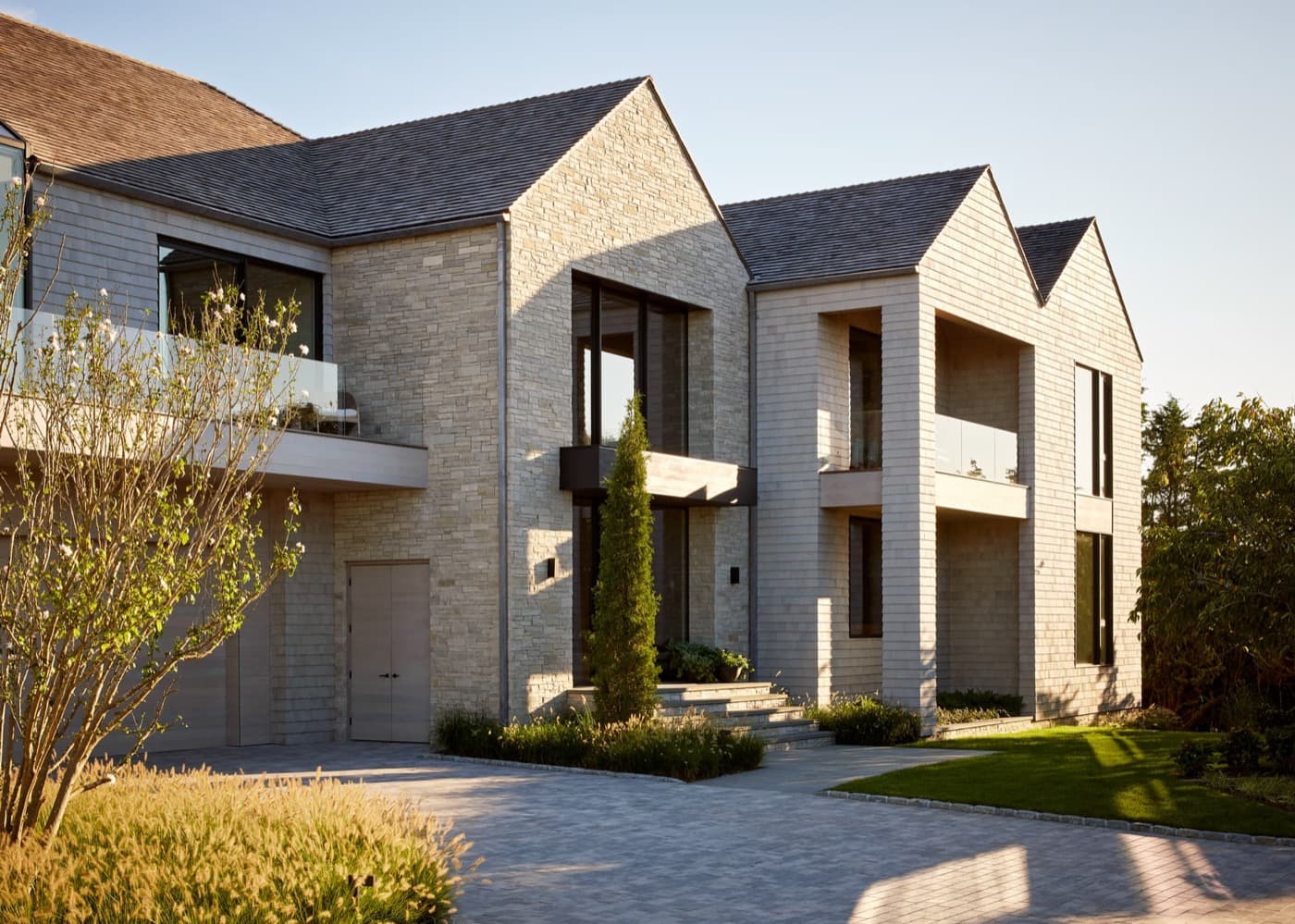Exterior facade featuring pale stone masonry, wood shingle siding, and multiple gabled rooflines