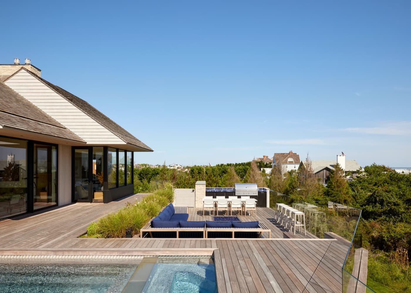 Outdoor timber deck featuring swimming pool, sunken lounge seating, dining area and outdoor kitchen