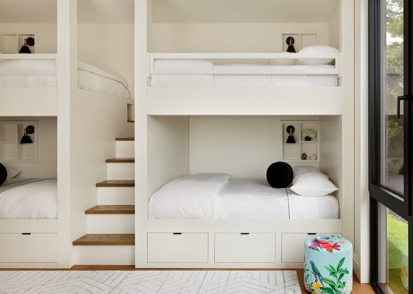 Bunk room featuring custom white built-in bunk beds with integrated stairs and storage drawers