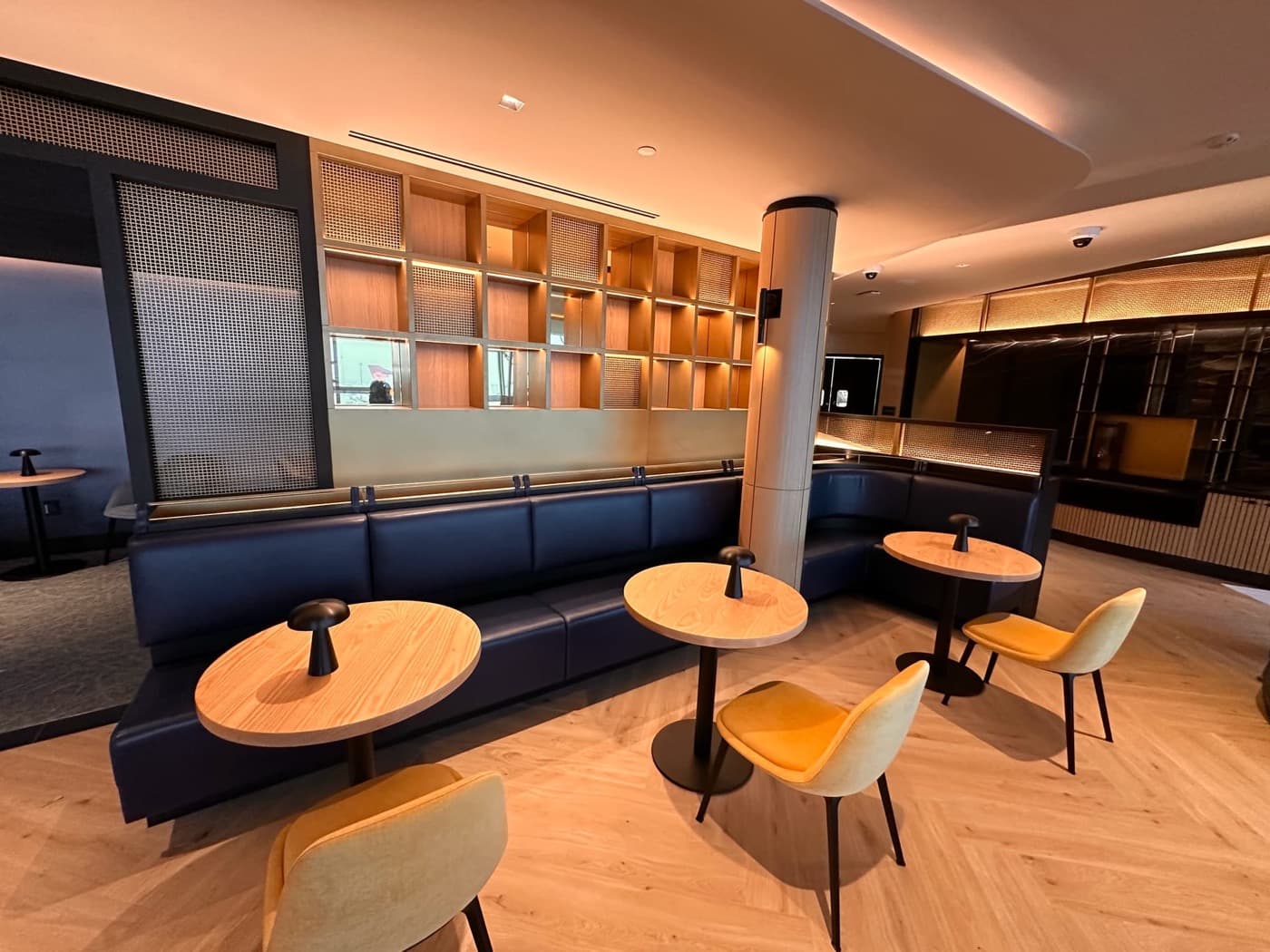 Lounge area featuring built-in banquette seating and illuminated timber grid wall shelving