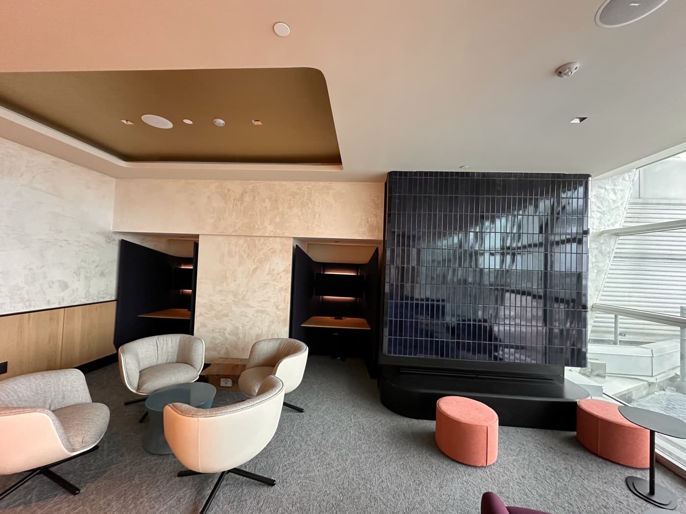 Office lounge with a dark tiled feature wall and built-in private work nooks