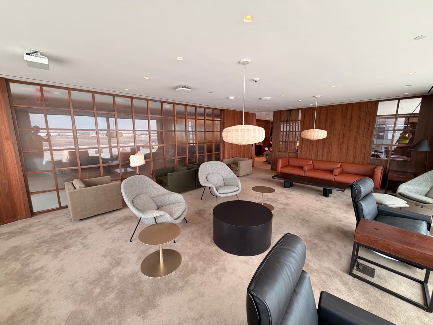 Spacious lounge featuring warm timber wall panelling and gridded glass partition screens
