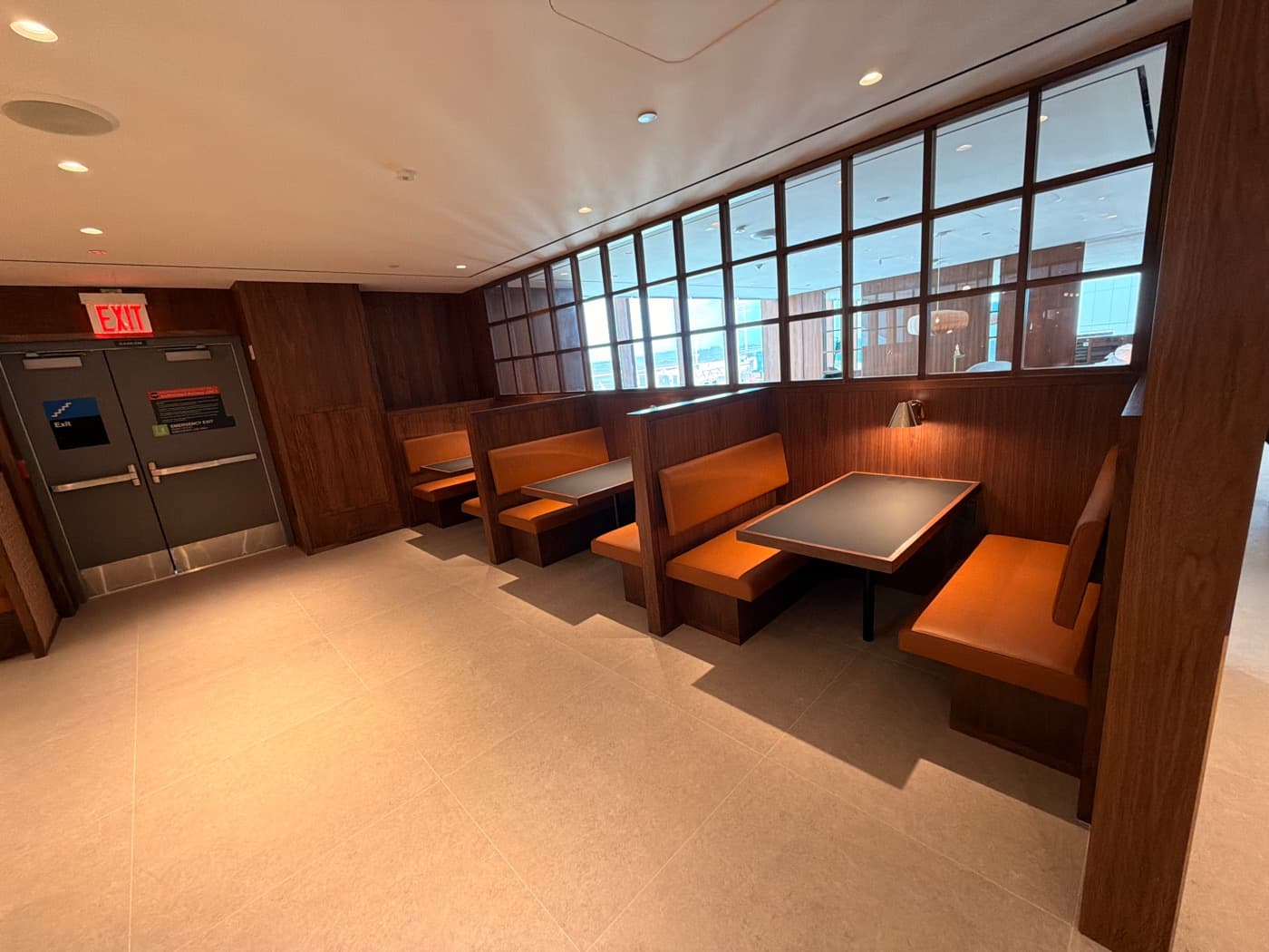 Dining space featuring built-in timber booth seating and a framed glass partition screen