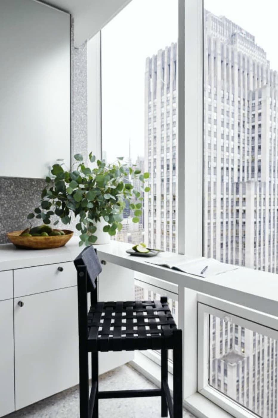 Kitchen nook with white built-in cabinetry and window counter overlooking city skyline