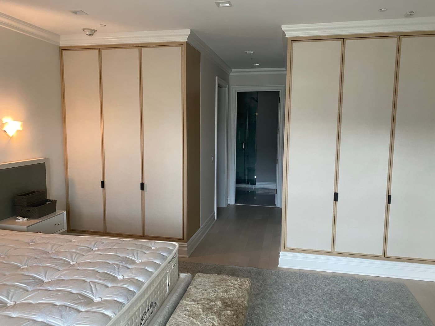 Bedroom with full-height built-in wardrobes featuring pale panel doors and light timber trim