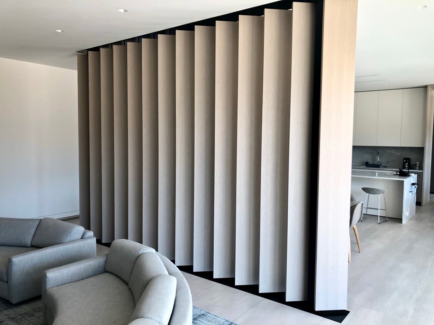 Living room featuring a floor-to-ceiling angled pale timber louvered screen partition