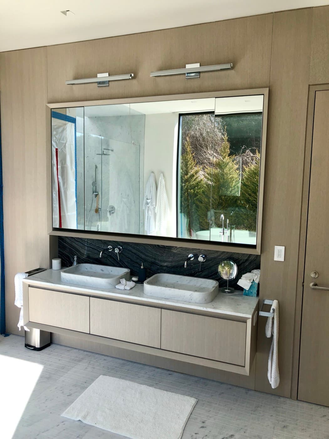 Bathroom with floating timber vanity, twin stone vessel sinks, and large framed mirrored cabinet
