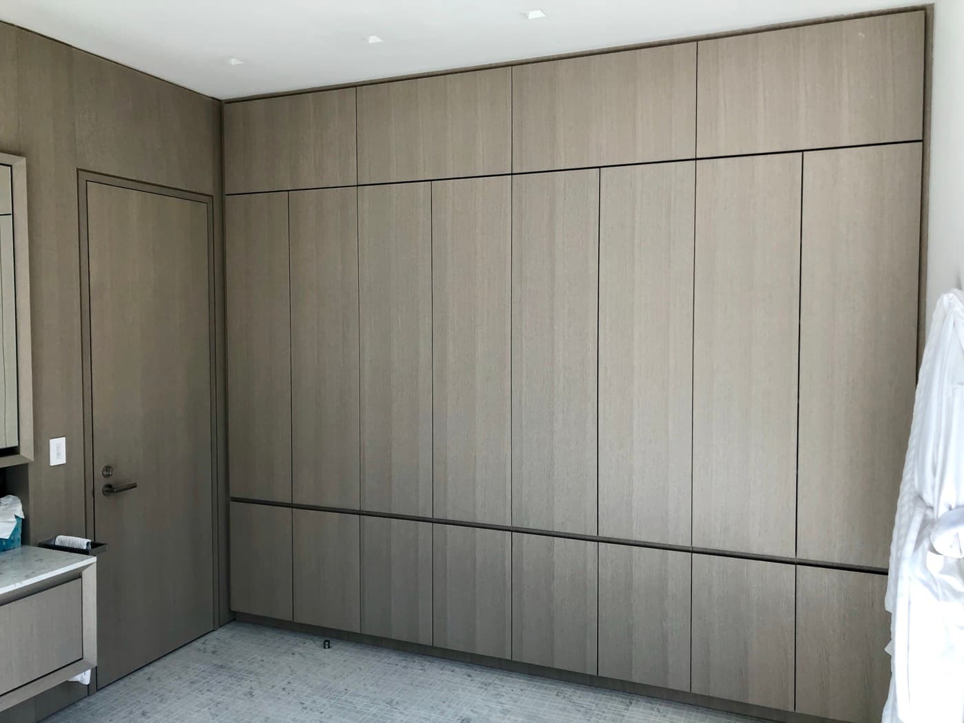 Bathroom dressing area featuring full-height timber built-in wardrobe cabinetry and a matching flush door