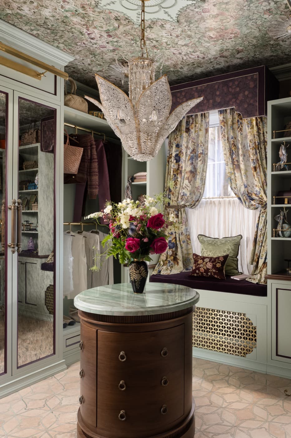 Dressing room with custom painted cabinetry, stone-topped island dresser, and built-in window seat