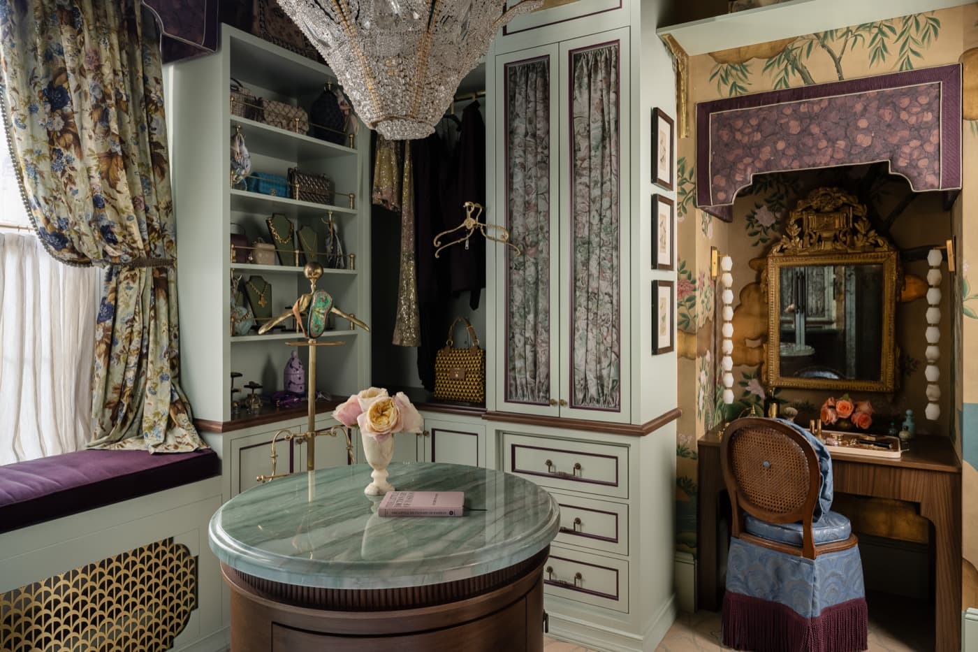 Dressing room with custom painted cabinetry, stone-topped island, and recessed vanity nook
