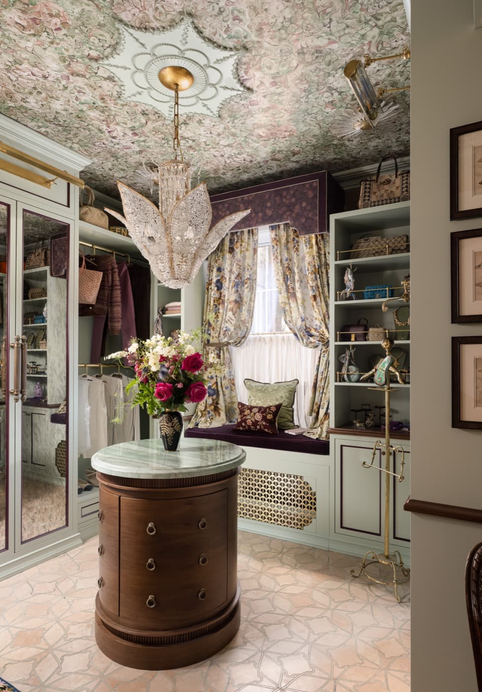 Dressing room featuring custom painted cabinetry, a window seat, and an oval timber island