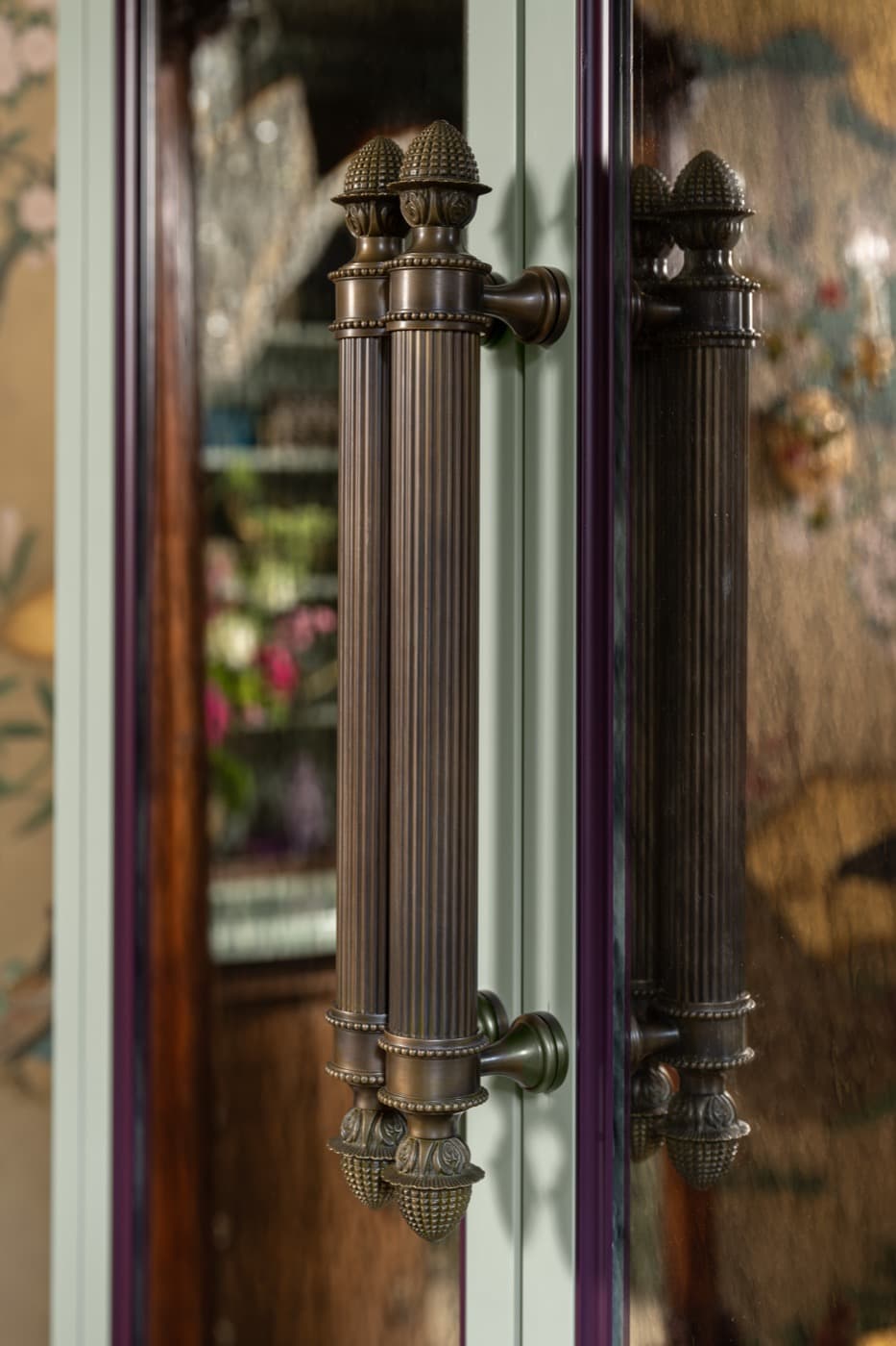 Living room custom cabinetry with fluted dark metal door pulls and antiqued mirrored panels