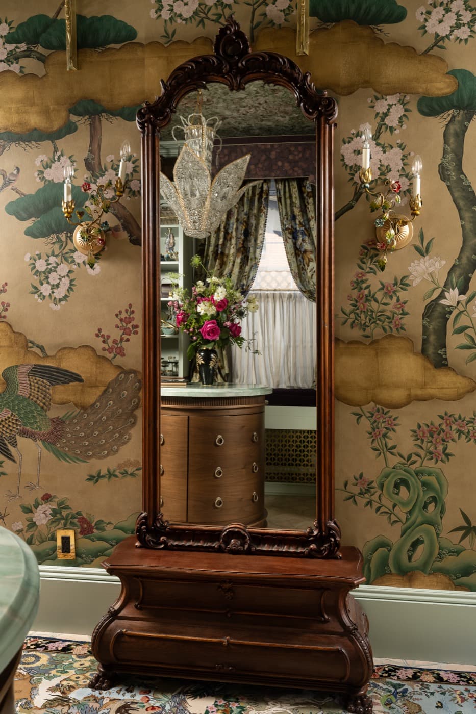 Dressing room with an ornate carved timber standing mirror reflecting a curved vanity cabinet