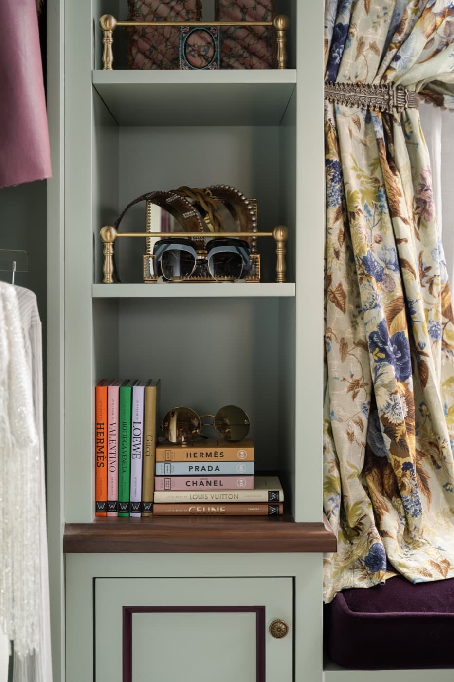 Dressing room built-in shelving unit with brass gallery rails and dark timber counter
