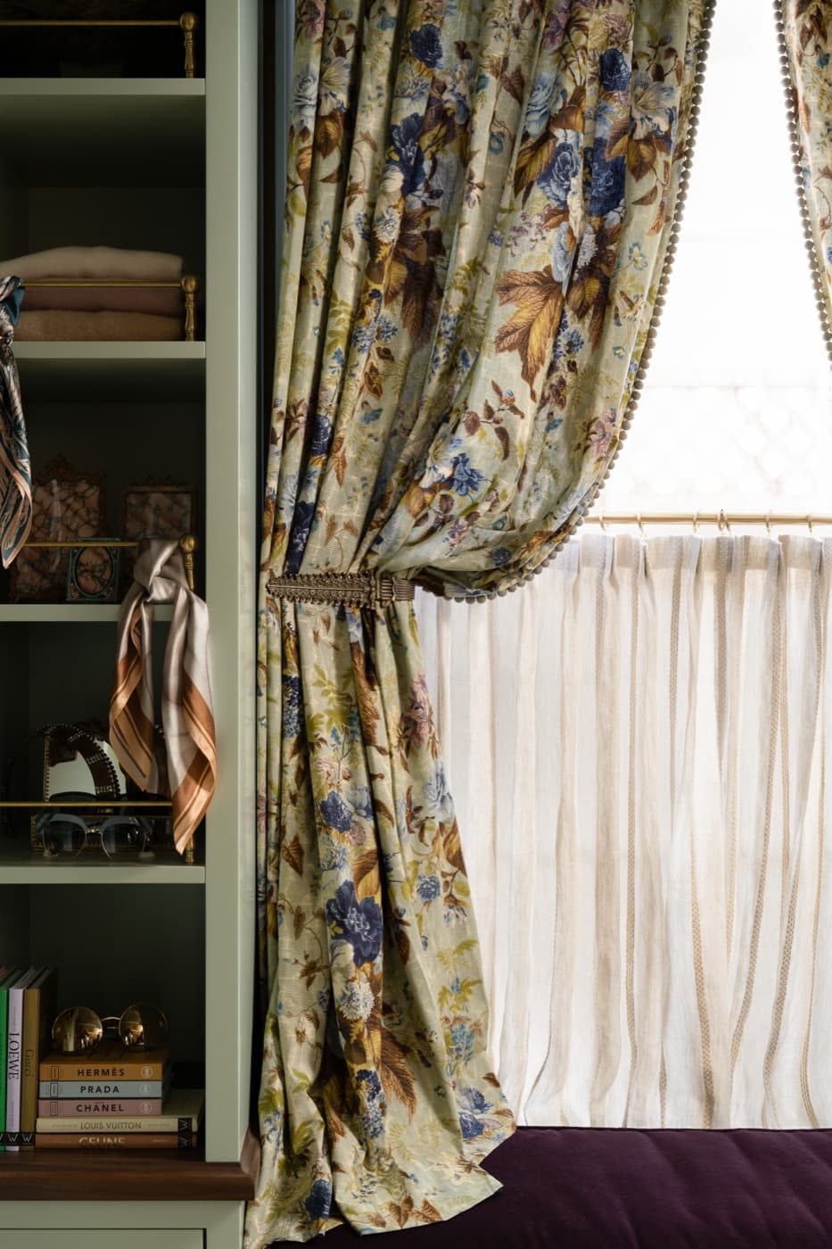 Dressing room featuring custom painted shelving alongside a cushioned window seat with floral drapery