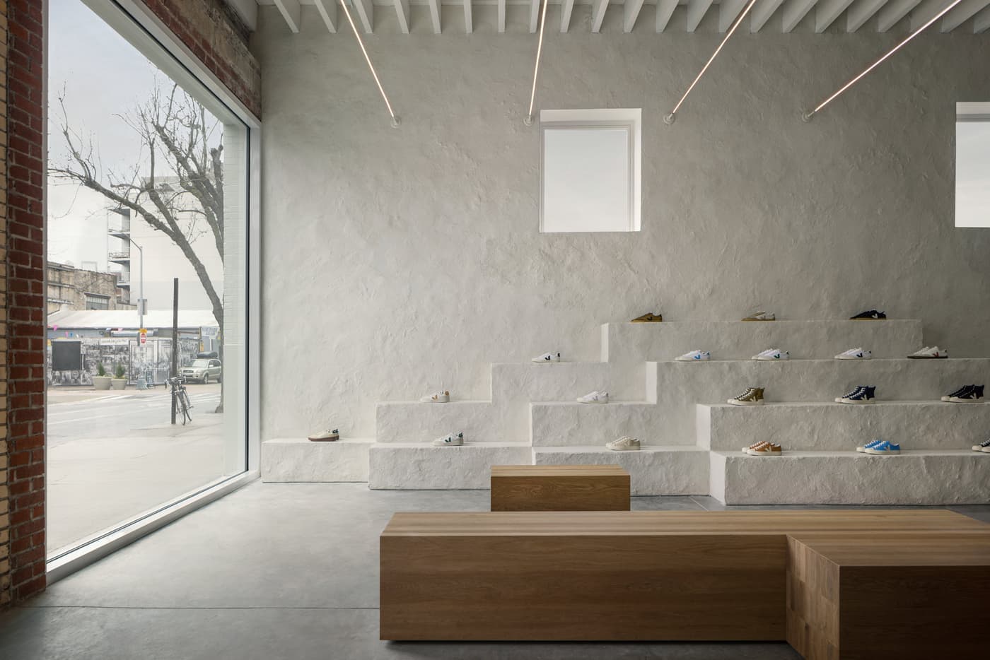 Retail space with textured white stepped display plinths and natural timber block benches