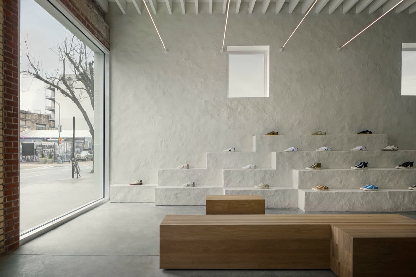 Retail space with textured white stepped display plinths and natural timber block benches