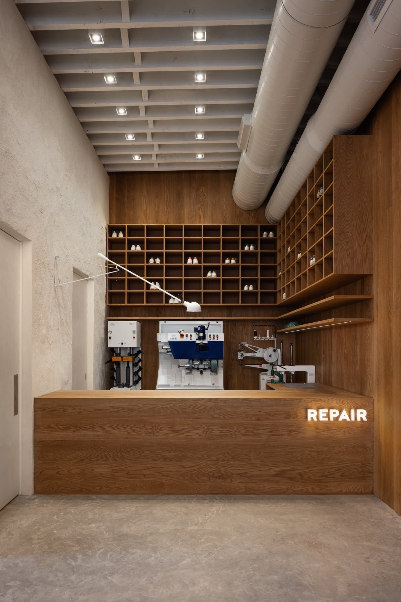 Commercial repair shop with custom timber counter, matching wall panelling, and built-in cubby shelving