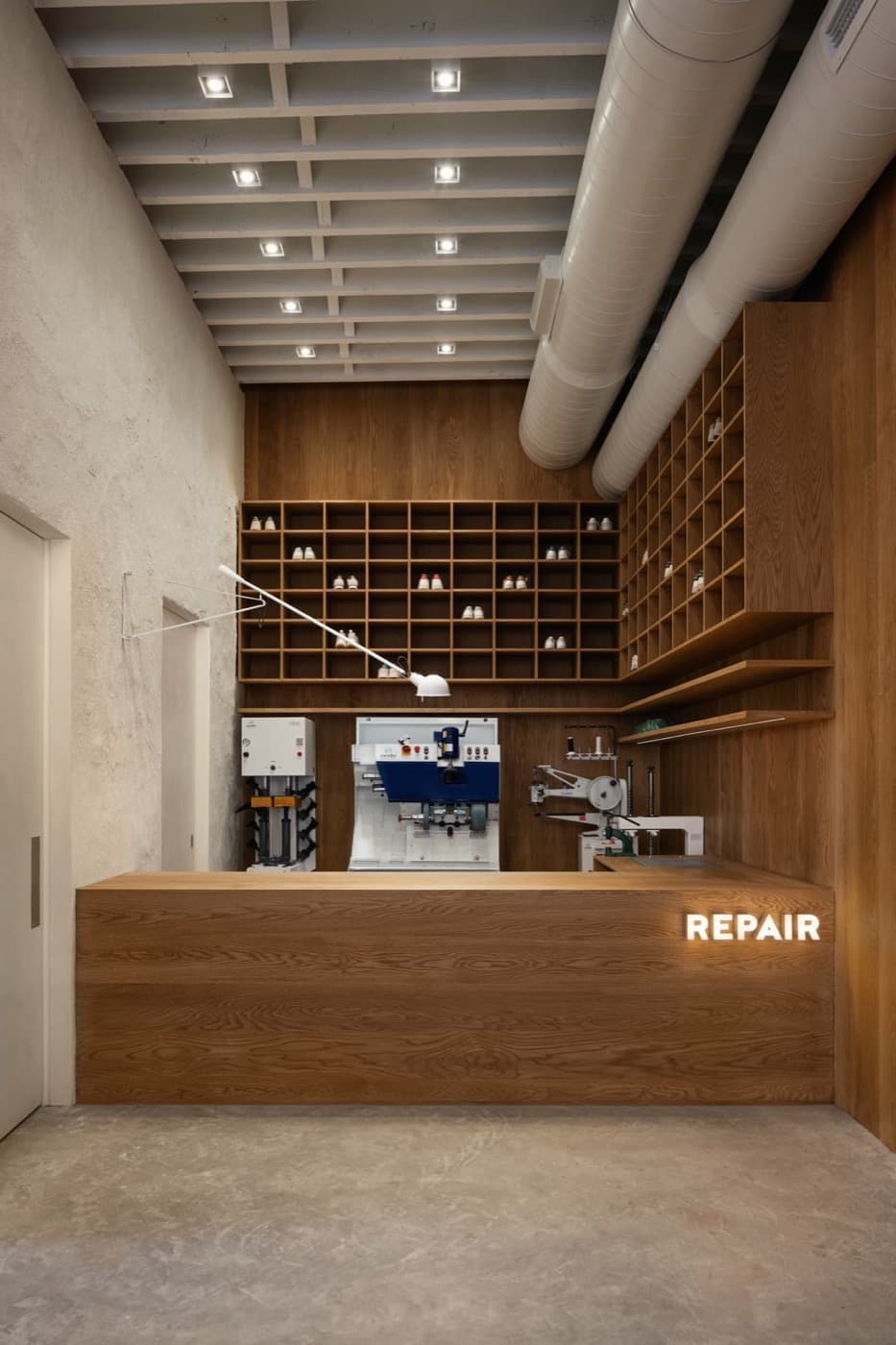 Commercial repair shop with custom timber counter, matching wall panelling, and built-in cubby shelving