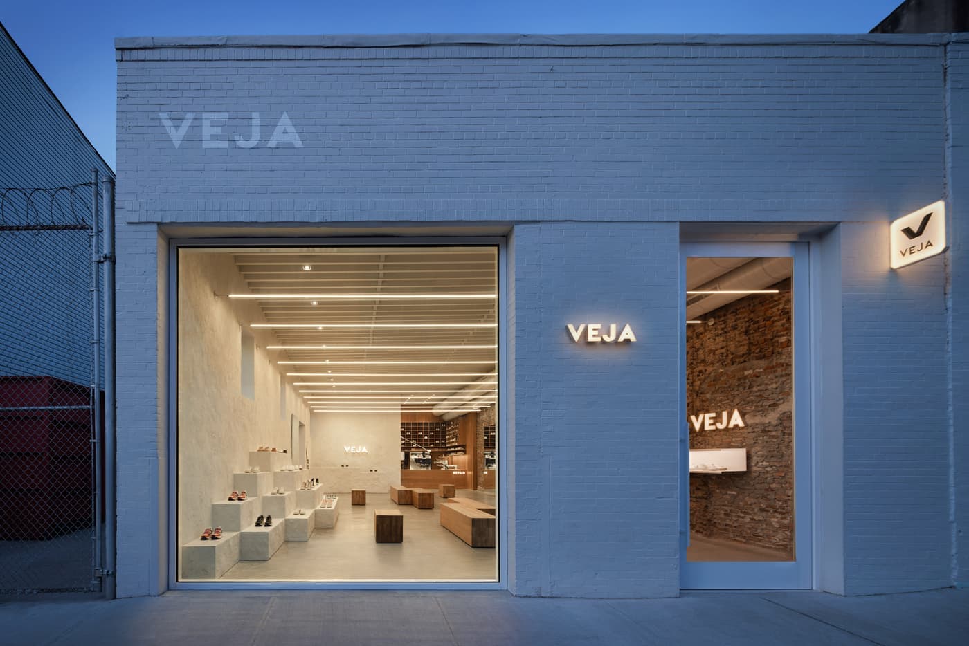 Retail storefront with painted brick facade, large picture window, and stepped interior display plinths