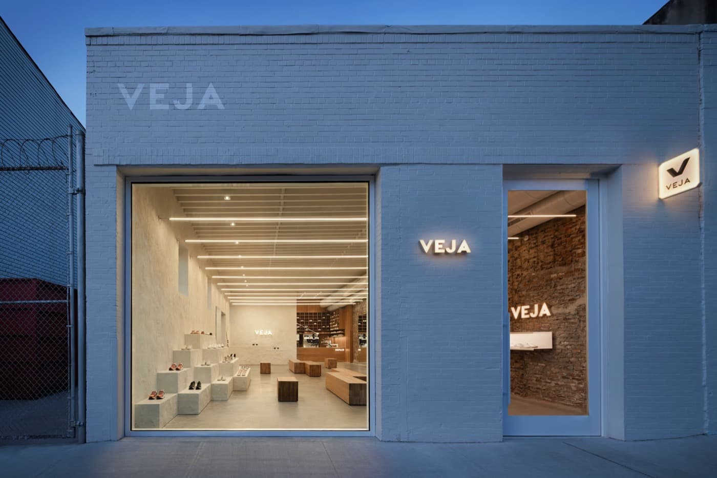 Retail storefront with painted brick facade, large picture window, and stepped interior display plinths