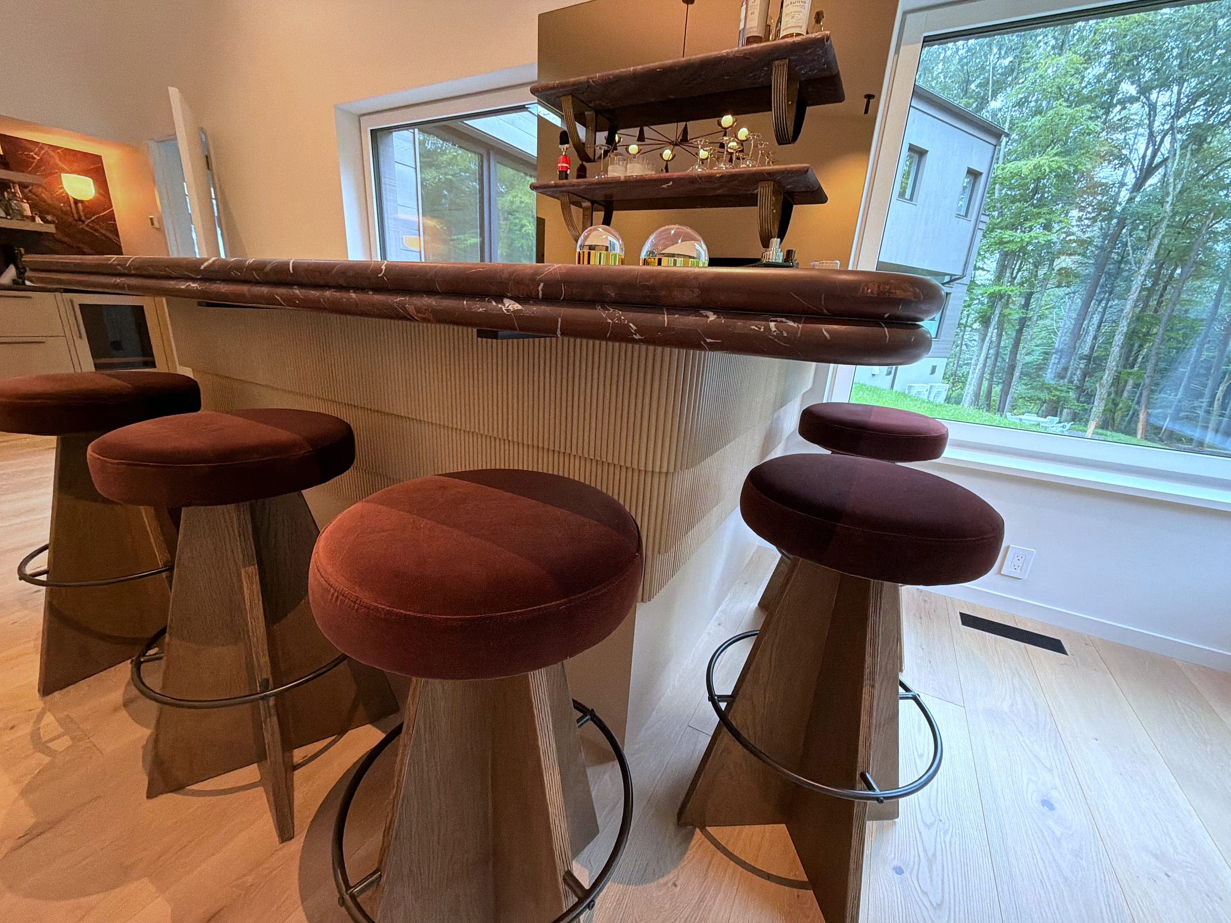 The bar at close range, showing the profiled Rosso Levanto edge above the fluted rift-sawn white oak base
